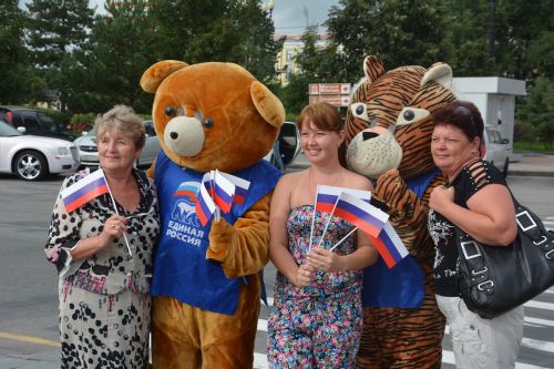 Члены «Молодой Гвардии», в костюмах тигра и медведя, раздавали жителям ленты и флажки в цвета российского триколора. Фото ХРО МГЕР