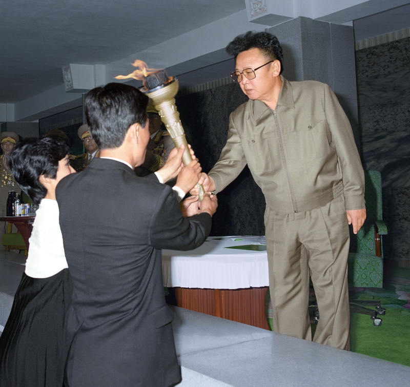 Ким Чен Ир передает представителям молодежи факел революции. Октябрь 1995 года.