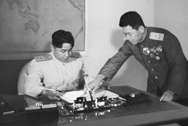 Великий вождь товарищ Ким Ир Сен утверждает документ о перемирии после его проверки. Июль 1953 года.