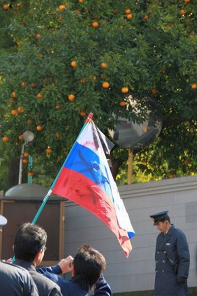 Оскверненный российский флаг в руках у представителя ультраправой организации в Японии. РИА Новости. Алан Булкаты